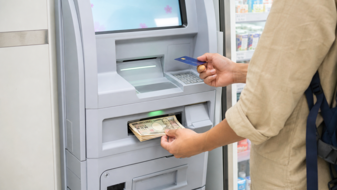 日本便利店ATM前使用海外银行卡提取日元的旅行者