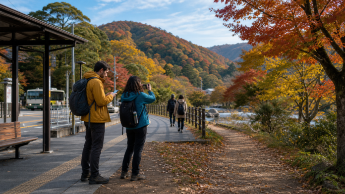 Travelers check a return timetable and photograph mixed autumn foliage beside a Japanese regional bus stop and maintained accessible path