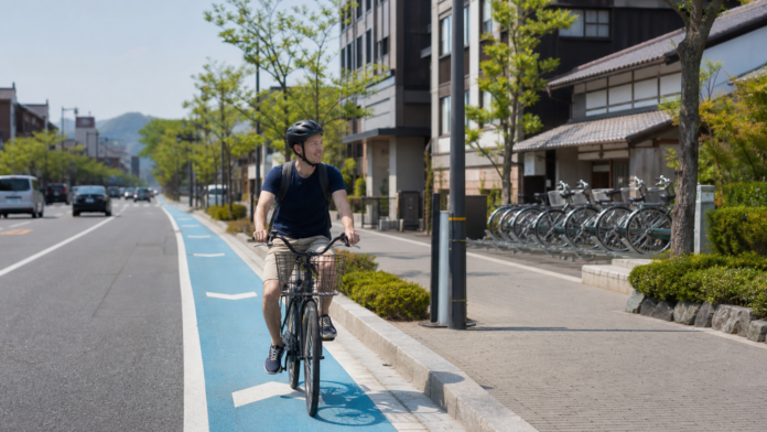 日本の自転車レーンをヘルメット着用で走るレンタサイクル利用者