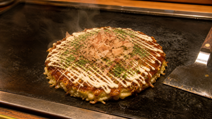 鉄板で焼き上がったソースと鰹節の大阪風お好み焼き