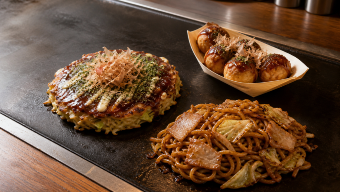 Osaka-style okonomiyaki, six takoyaki and sauce yakisoba arranged separately on an iron griddle