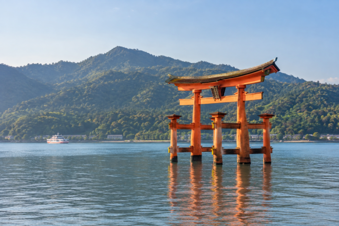 Itsukushima Shrine torii in the sea with Mount Misen on Miyajima